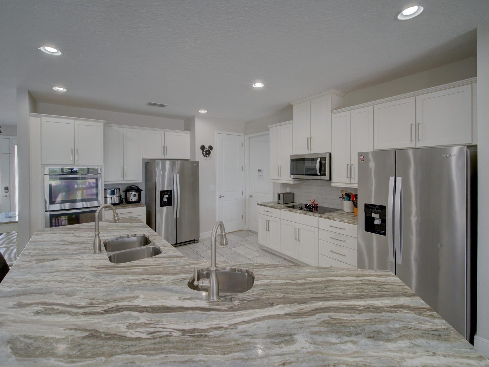 Open plan kitchen with double island and stainless appliances in an Orlando vacation rental